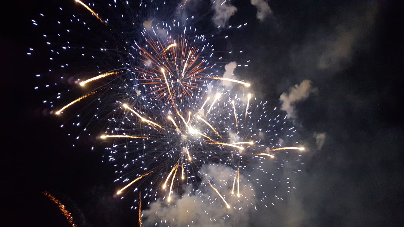 Höhenfeuerwerk mit goldenen und weißen Effekten am Nachthimmel